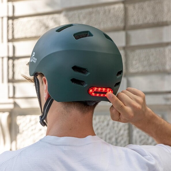 Personne de dos actionnant le feu arrière LED rouge intégré à son casque Urban Prime