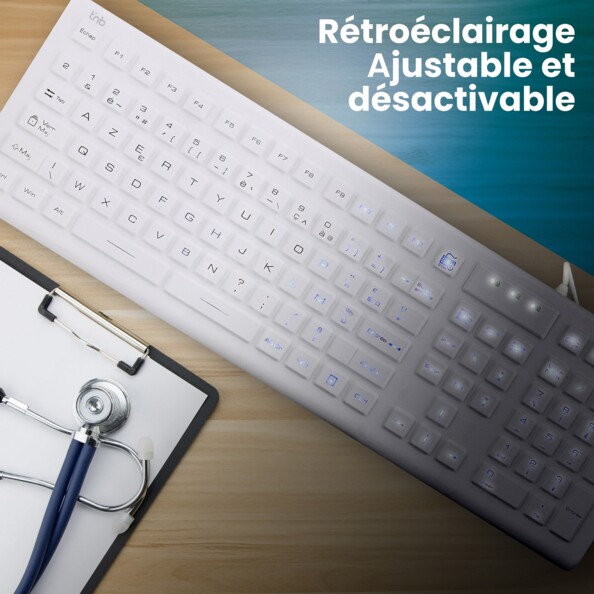 Vue du dessus du clavier dans une ambiance mi sombre mi lumineuse sur un bureau à côté d'un bloc-notes de médecin mettant en situation le rétroéclairage commutable à intensité variable