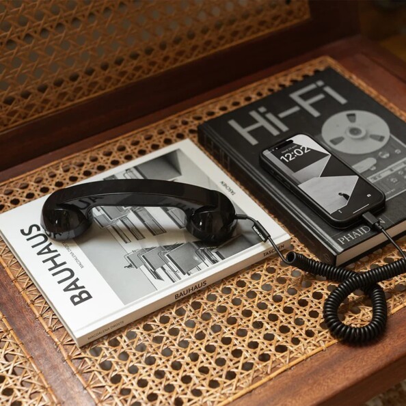Combiné vintage noir Native Union posé sur livres Bauhaus et Hi-Fi avec smartphone