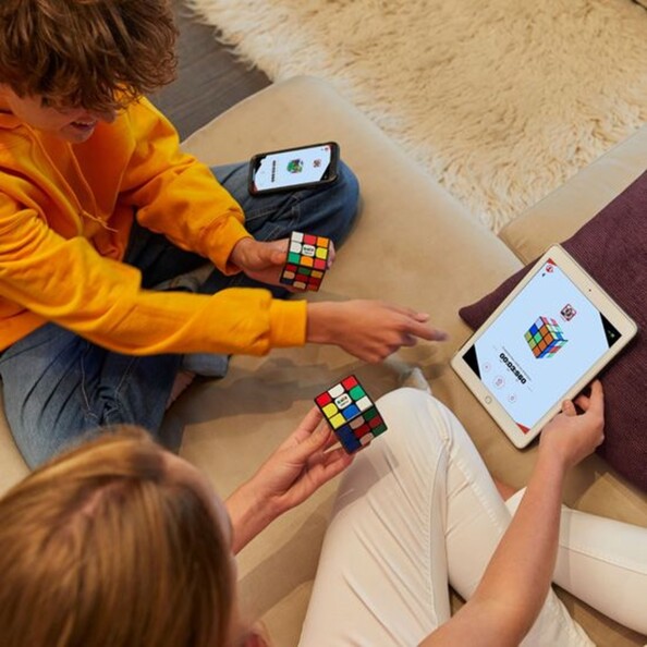 Mise en situation d'un défi de résolution de Rubik's cube entre une fille et un garçon avec affichage de la durée sur l'écran d'une tablette