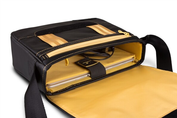 Mise en situation de l'insertion d'une tablette maintenue par élastique dans le compartiment principal couleur safran du sac bandoulière bicolore