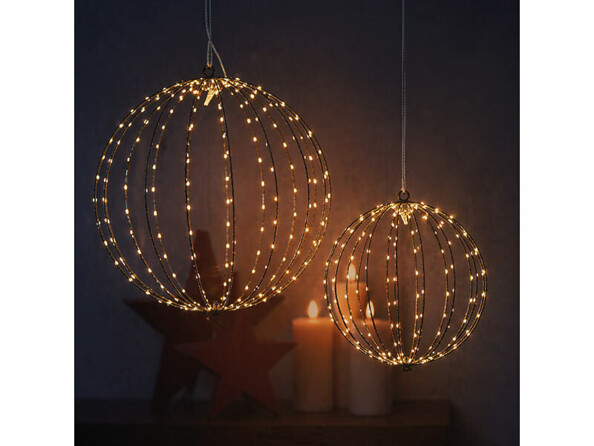 2 sphères lumineuses en fil métallique de tailles différentes avec micro LED blanc chaud, bougies et étoile rouge en arrière-plan