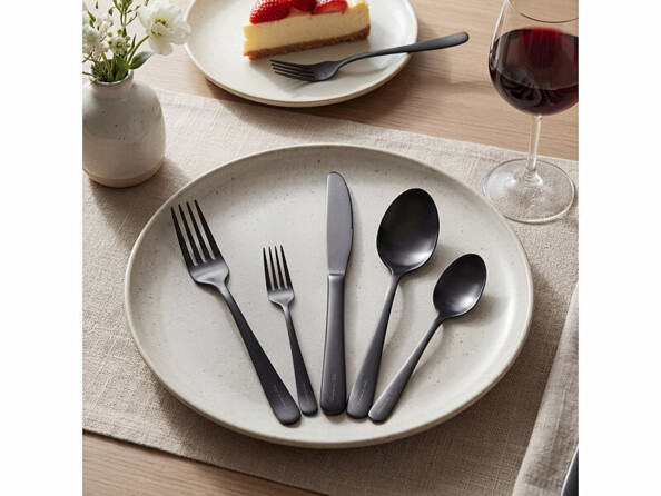 couverts de table en acier inoxydable noir mat disposés dans une assiette
