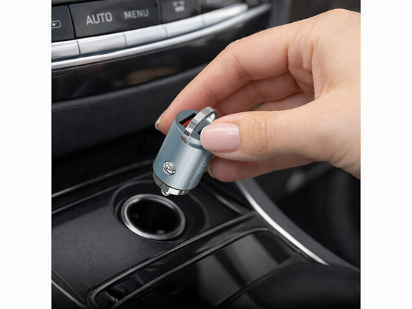 Main mettant en place dans une voiture le chargeur allume-cigare USB-A / USB-C