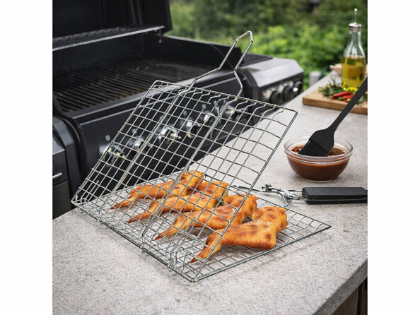 Panier à grillades en acier inoxydable ouverte mis en situation devant un barbecue avec des ailes de poulet