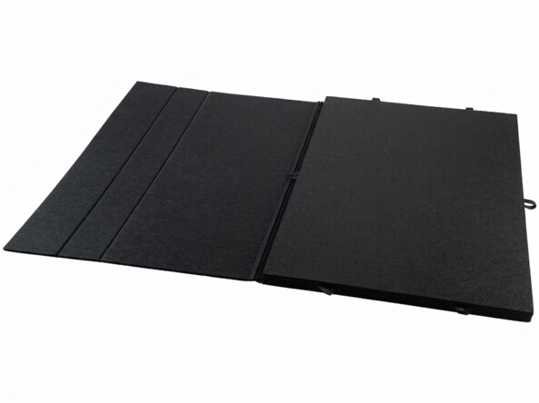 Tapis noir pliable en panneaux avec poignées latérales, sur fond blanc