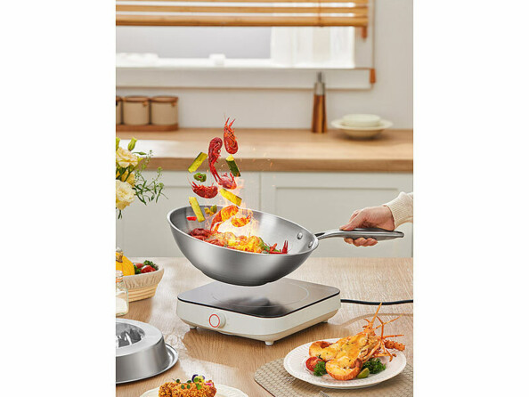 Wok en acier inoxydable 28 cm mis en situation dans une cuisine avec des aliments sautés