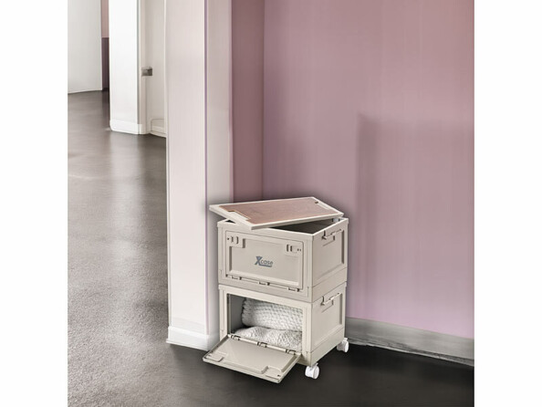 Mise en situation de deux boîtes de rangement empilées sur quatre roues et installées dans un coin