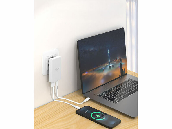 Chargeur secteur plat USB-A / USB-C 30 W vu de coté chargeant un smartphone et un ordinateur sur un bureau