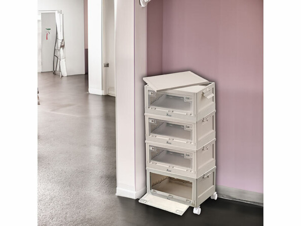 Mise en situation de quatre boîtes de rangement empilées sur quatre roues et installées dans un coin