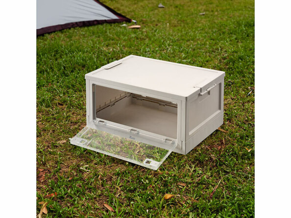 Caisse de rangement pliable posée au sol en extérieur avec paroi vitrée ouverte