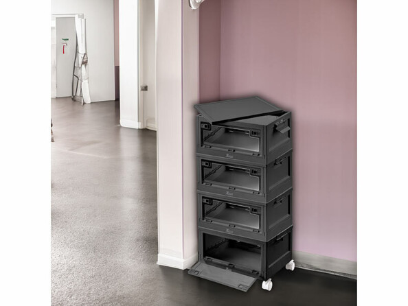 Mise en situation de quatre boîtes de rangement empilées sur quatre roues et installées dans un coin