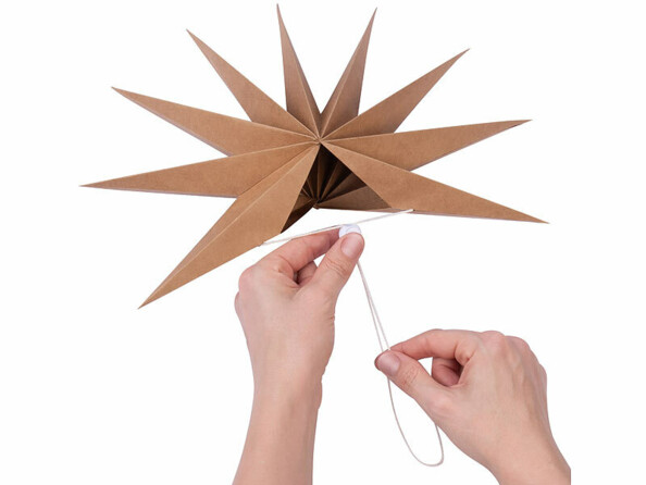 étoile pliable en papier Ø 30 cm coloris brun vue de dessous avec mains qui la referment