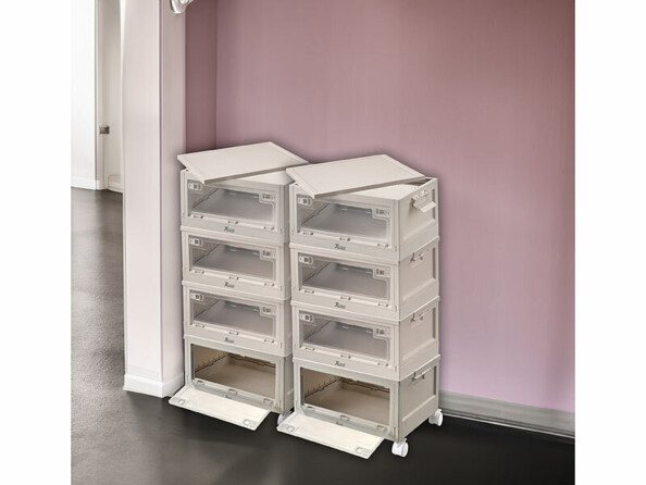 Mise en situation de huit boîtes de rangement empilées sur huit roues et installées dans un coin