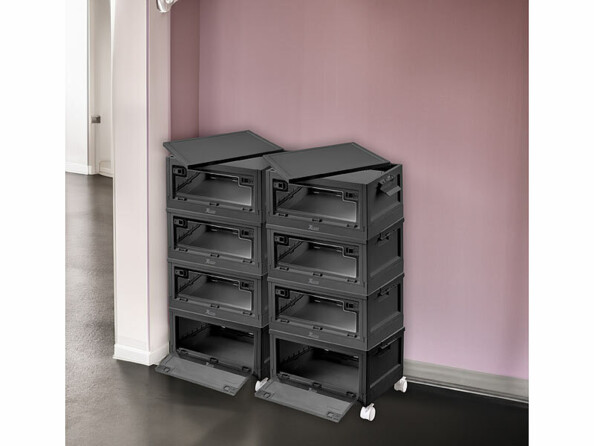 Mise en situation de huit boîtes de rangement empilées sur huit roues et installées dans un coin