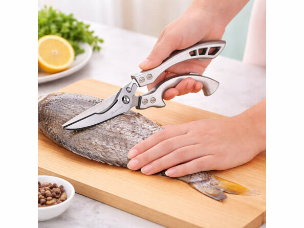 Ciseaux de cuisine n acier inoxydables mis en situation entrain de d'écailler un poisson sur un plan de travail