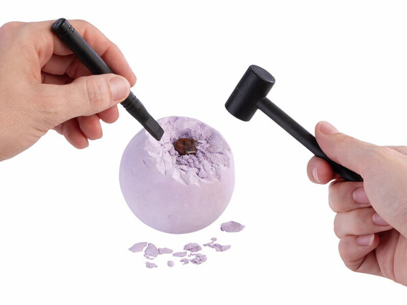 boule de platre cassée avec un marteau et un burin pour extraire des pierres précieuses