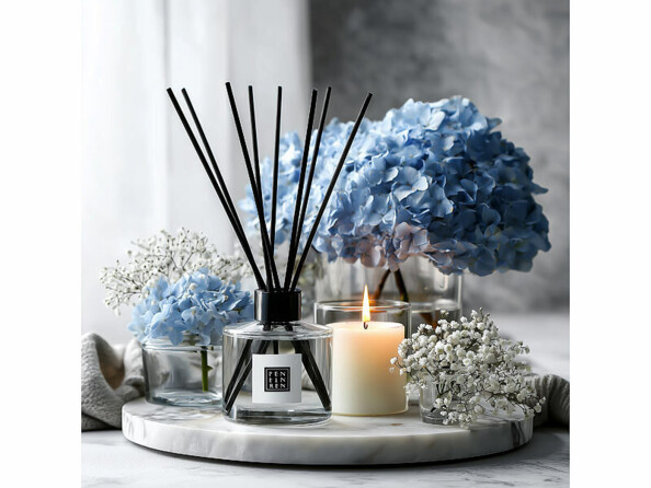diffuseur de parfum à bâtonnets sur une table avec des bougies et des hortensias