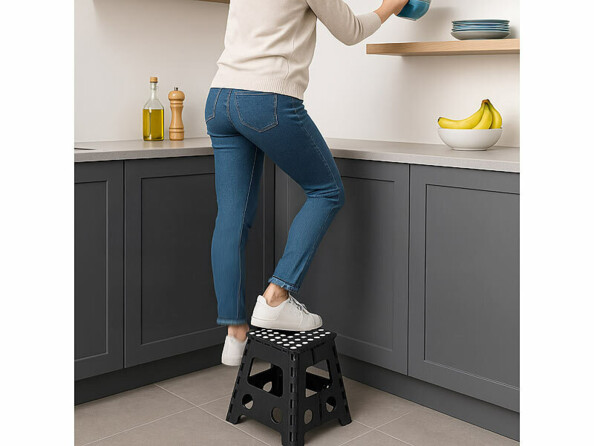 Marchepied pliable antidérapant 39 cm mis en situation dans une cuisine avec une femme grimpant dessus