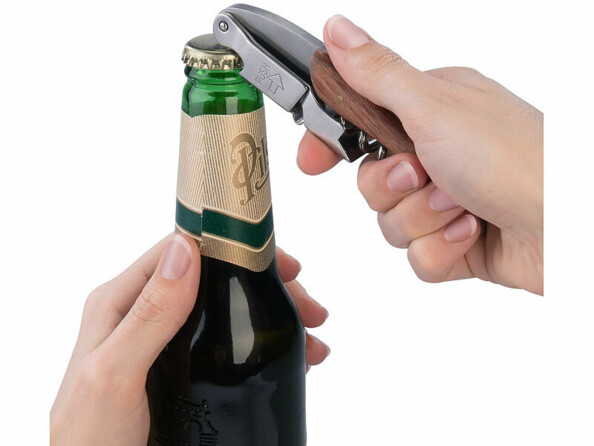 Tire-bouchon de sommelier avec décapsuleur mis en situation entrain de décapsuler une bouteille de bière