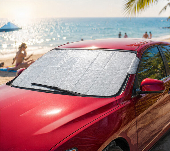 Housse de protection de pare-brise réfléchissante sur voiture au bord de la plage