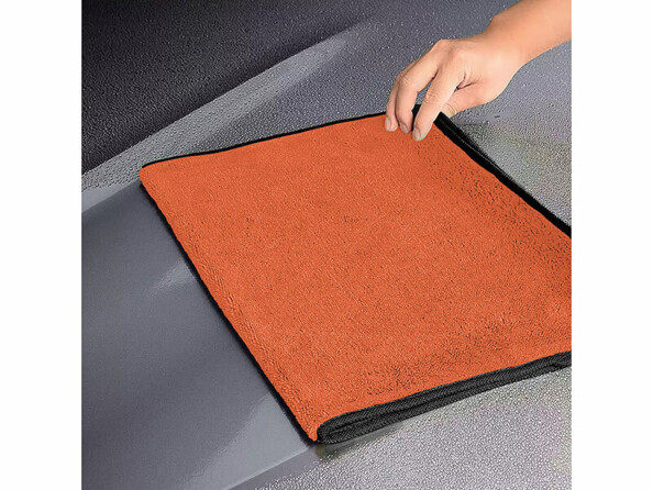 Chiffon en microfibre essuyant le capot d'une voiture