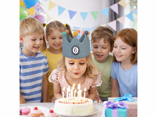 Couronne d'anniversaire pour enfant mise en situation sur la tête d'un fillette pendant une fête d'anniversaire