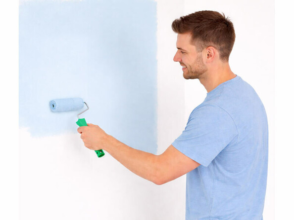 personne peignant un mur avec un petit rouleau