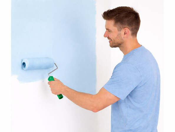 personne peignant un mur avec un rouleau