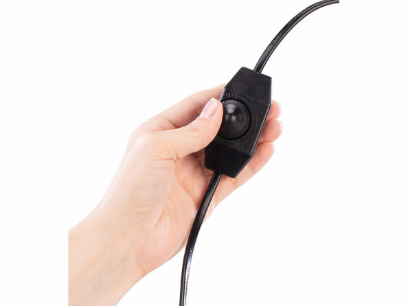 Main manucurée réglant le variateur rotatif noir du câble d’une lampe de sel