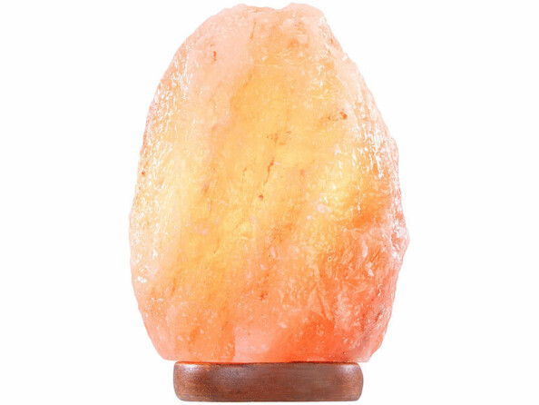 Lampe de sel rose de l’Himalaya Lunartec de forme brute et irrégulière, éclairée de l’intérieur, posée sur un petit socle en bois foncé, vue de trois quarts sur fond blanc