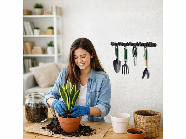 Support mural pour outils mis en situation avec outils de jardin et femme horticultrice