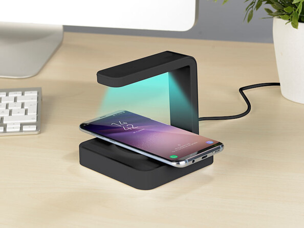 La station de chargement Qi avec lampe de désinfection UVC posée sur un bureau.