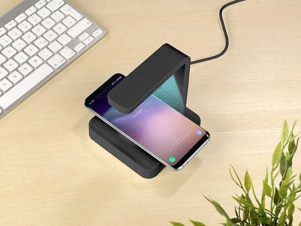 Un téléphone entrain de charger sur la station Qi équipée d'une lampe UVC.