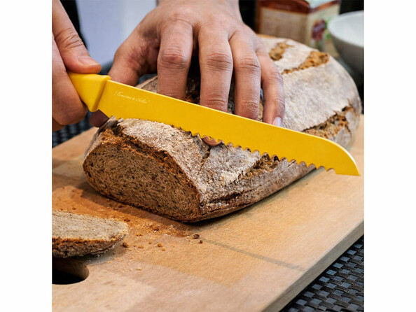 couteau à pain jaune entrain de trancher une miche