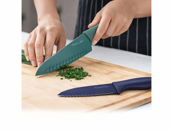 2 couteaux de cuisine, l'un posé sur une planchette et l'autre entrain de ciseler des herbes