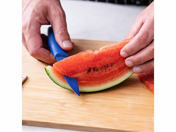 couteau à éplucher bleu entrain de trancher une pastèque