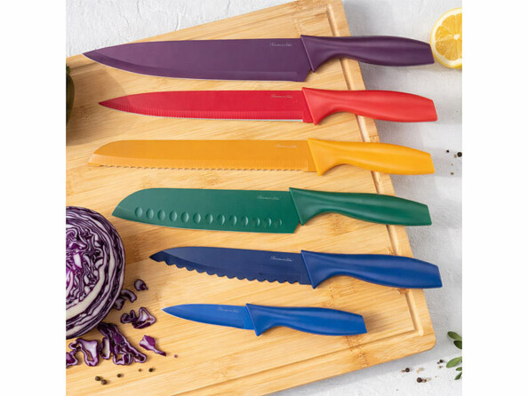 6 couteaux de cuisine colorés en acier inoxydable posé sur une planche à découper en bambou