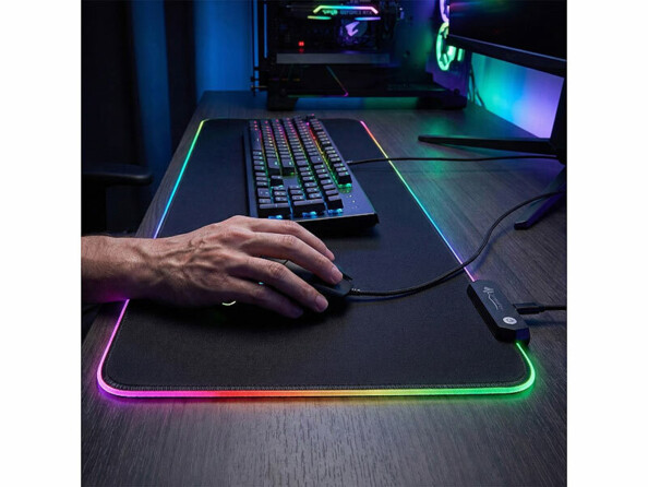 Tapis de souris gaming 80 x 30 cm avec éclairage LED mis en situation sur un bureau avec setup gaming et main sur la souris