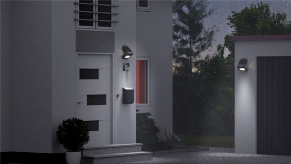 Applique murale solaire Goobay noire, deux luminaires allumés sur une maison en situation nocturne