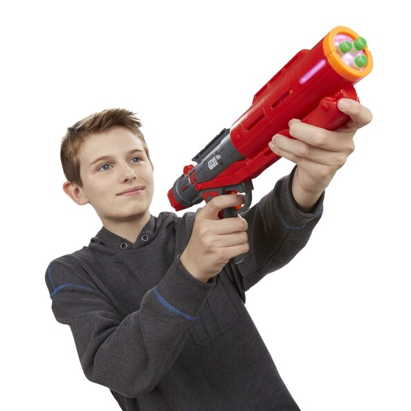 Jeune garçon tenant le blaster Nerf Star Wars avec deux mains dont une sur la crosse et la gâchette et l'autre sur le système de pompe visant une cible au loin