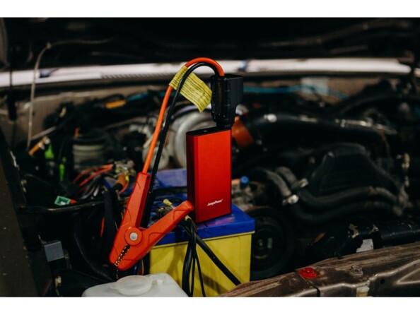 Booster de batterie automobile et batterie externe USB posé sur la batterie d'un moteur d'un véhicule avec le capot ouvert