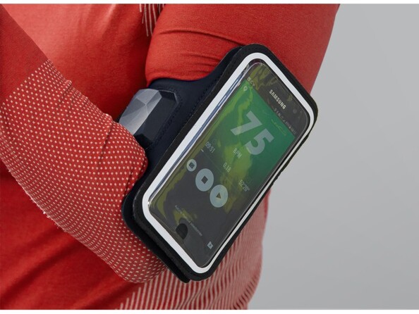 Plan rapproché sur un smartphone Android en lecture audio protégé par la pochette transparente du bandeau magnétique fixé au bras d'une joggeuse