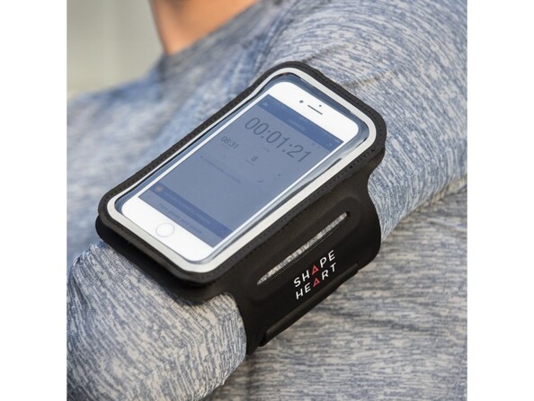 Mise en situation du brassard installé au tour du biceps d'un homme en pulle avec un smartphone allumé sur la fonction chronomètre