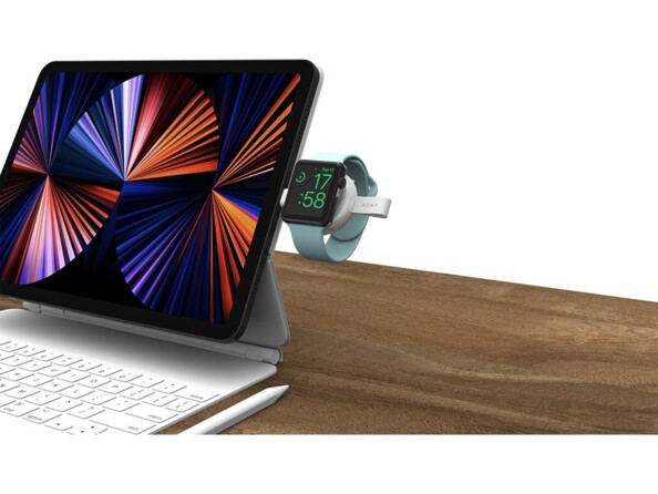 Mise en situation du mini chargeur portable sans fil avec connecteur USB-C branché au port USB-C d'un iPad avec clavier pliable et recharge en cours d'une montre connectée Apple sur sa surface magnétique
