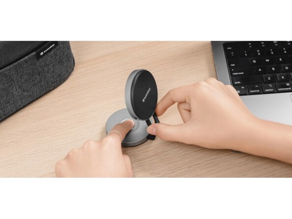 Réglage de la hauteur du support magnétique compatible MagSafe à deux mains par une personne sur un bureau