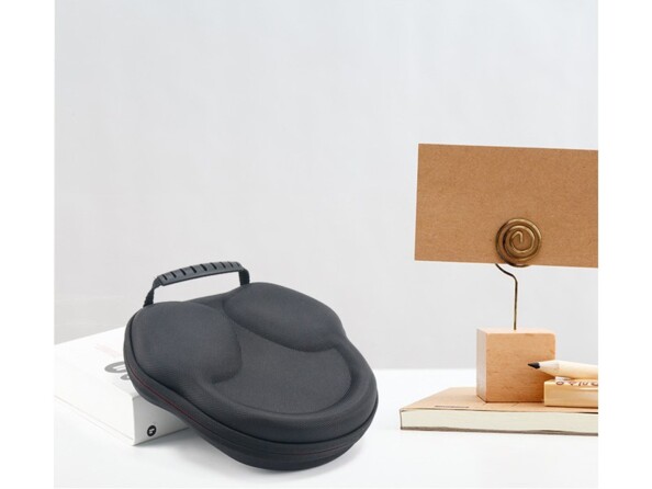 Housse de rangement coloris noir et rouge pour Apple AirPods Max posé à côté de décorations en bois