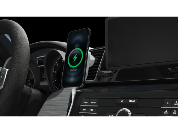 Mise en situation du chargeur MagSafe fixé à une grille de ventilation du tableau de bord d'une voiture avec un smartphone compatible MagSafe en cours de chargement sur sa surface à induction aimantée