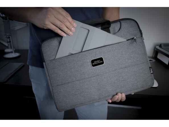 Rangement du tapis de souris multifonction dans la pochette d'une sacoche pour PC par un homme en jean et t-shirt