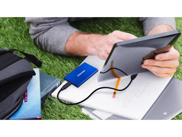 Mise en situation d'un disque dur externe branché à une tablette utilisée en extérieur par un étudiant